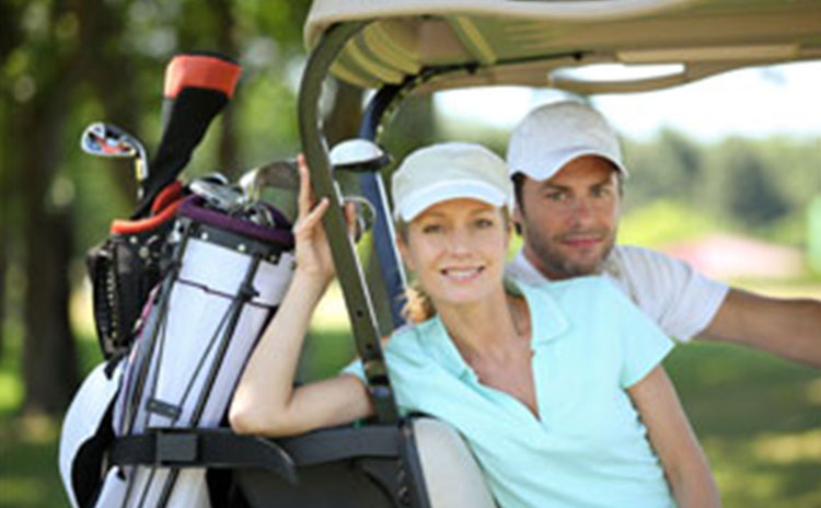 view of golfers in golf cart with golf bags